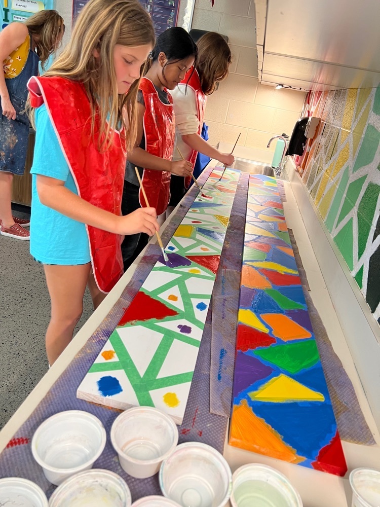 5th graders painting a new coat rack for lost and found. 